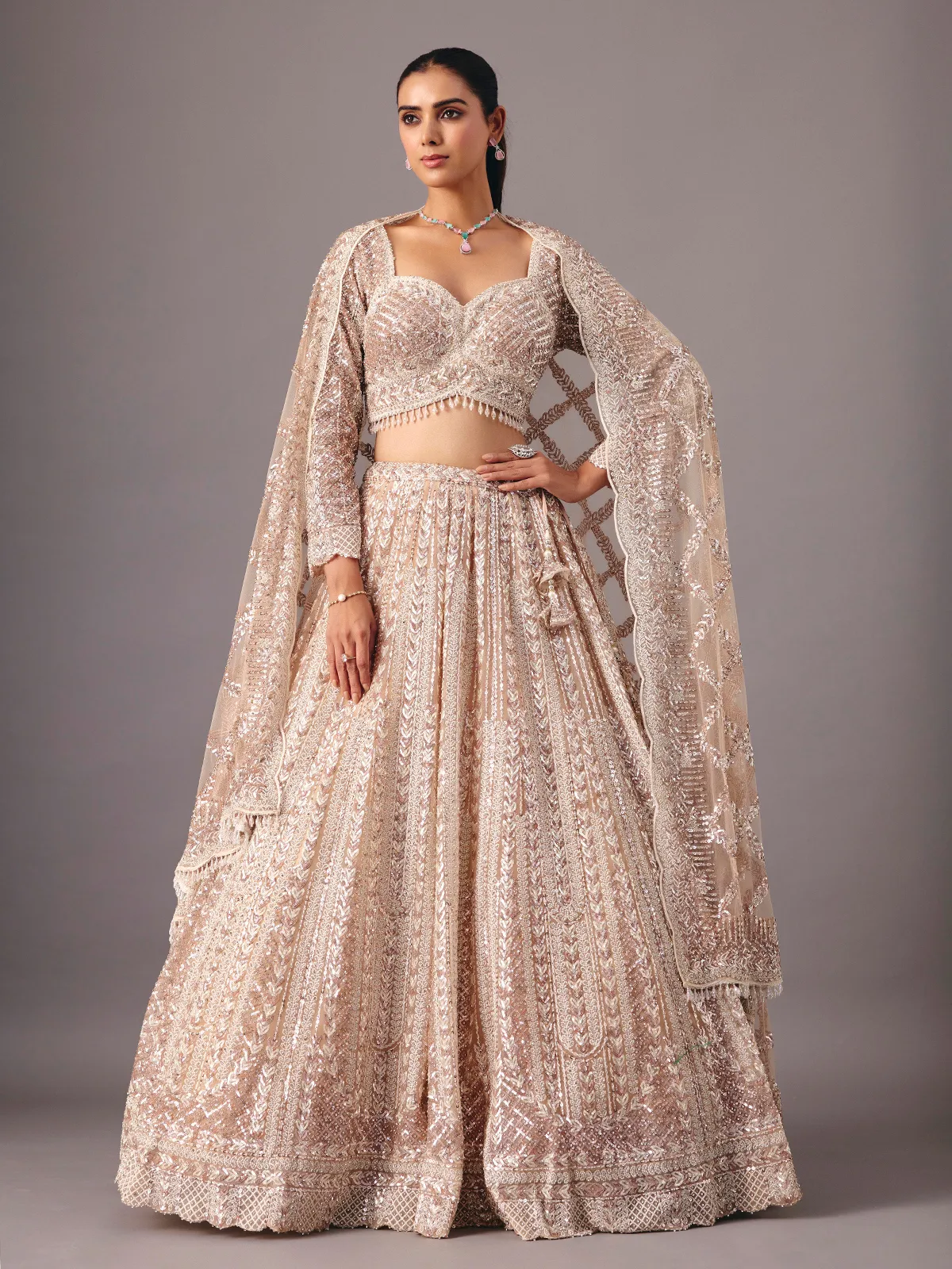 Beige net lehenga choli with pearl and sequin detailing
