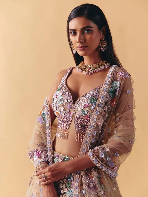 Beige net lehenga choli with beaded and pearl accents
