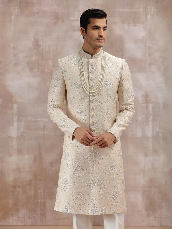 Beige silk sherwani highlighted with resham work