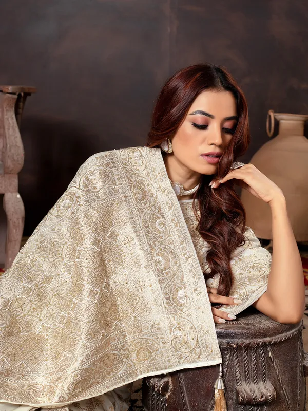 Cream dola silk saree with zari embellishment