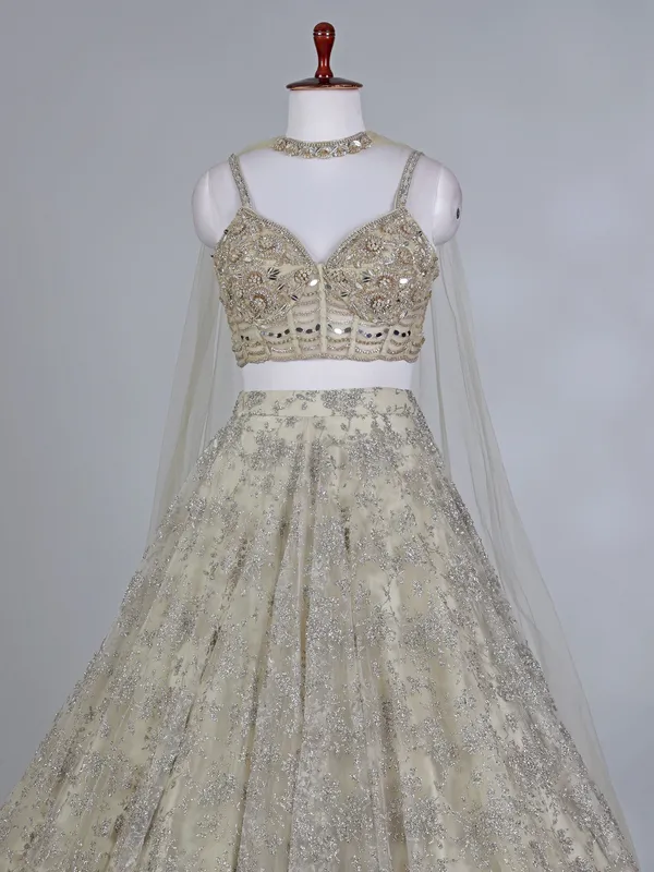 Cream net bridal lehenga choli with zardosi work