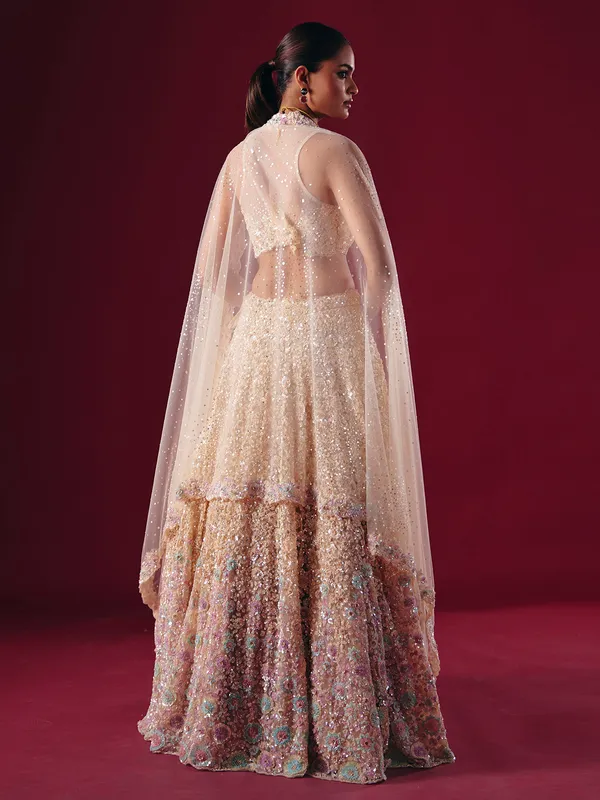 Cream net lehenga choli with cutdana embellishment