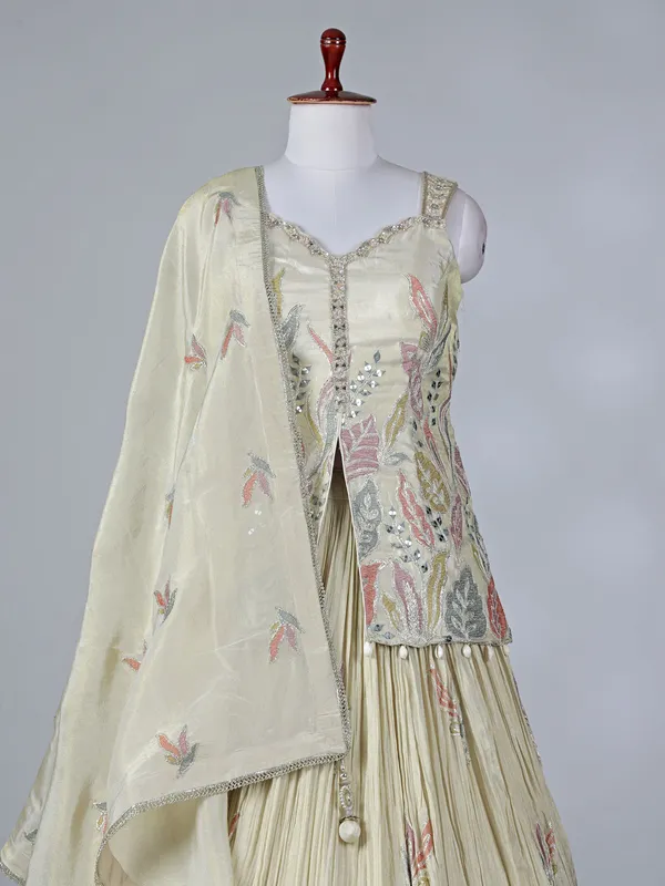 Cream silk lehenga choli with cowrie shells work