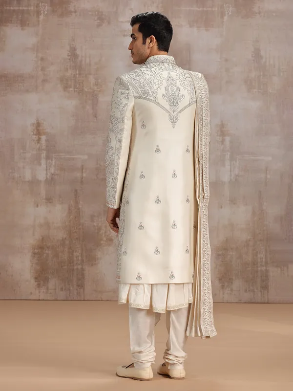Cream silk peshwai sherwani paired with dupatta