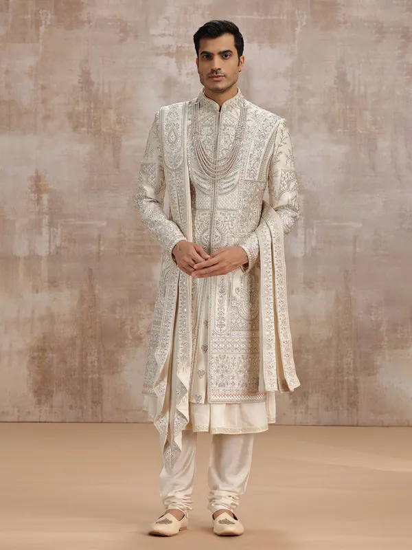 Cream silk peshwai sherwani paired with dupatta