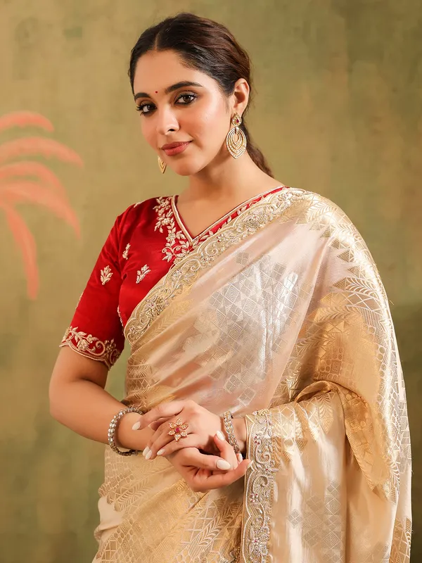 Cream silk saree for wedding celebration with red blouse