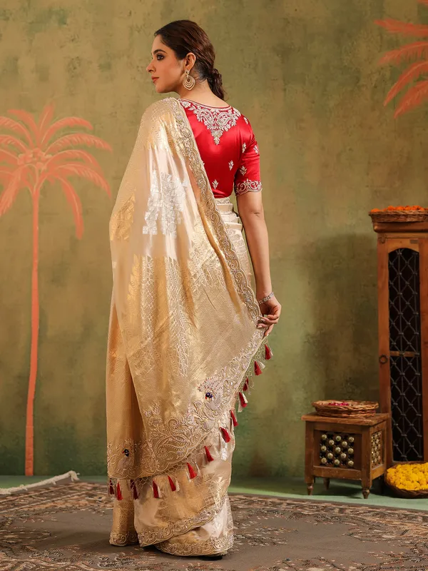 Cream silk saree for wedding celebration with red blouse