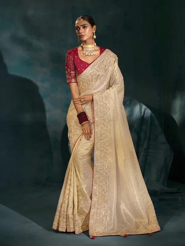 Cream silk wedding wear saree with bold maroon blouse