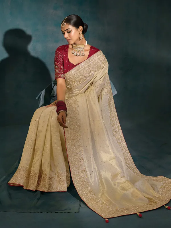 Cream silk wedding wear saree with bold maroon blouse