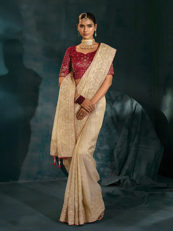 Cream silk wedding wear saree with bold maroon blouse