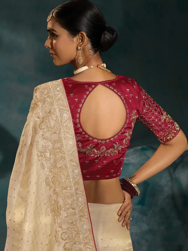 Cream silk wedding wear saree with bold maroon blouse