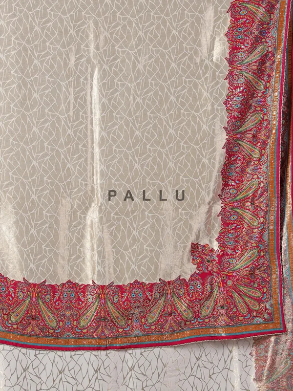 Cream tissue silk saree with colorful motifs embellishments