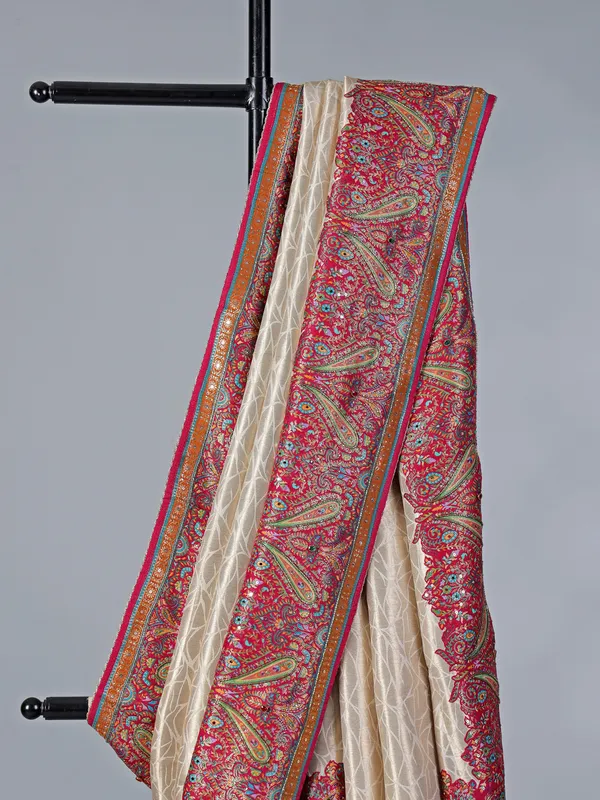 Cream tissue silk saree with colorful motifs embellishments