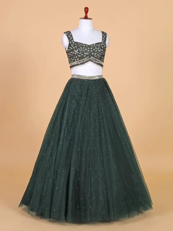 Fascinating dark green net lehenga choli