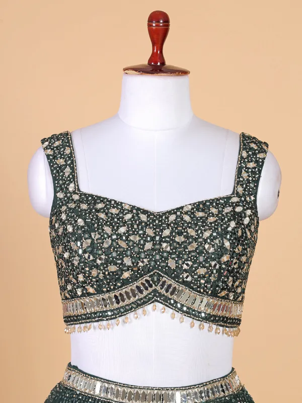 Fascinating dark green net lehenga choli