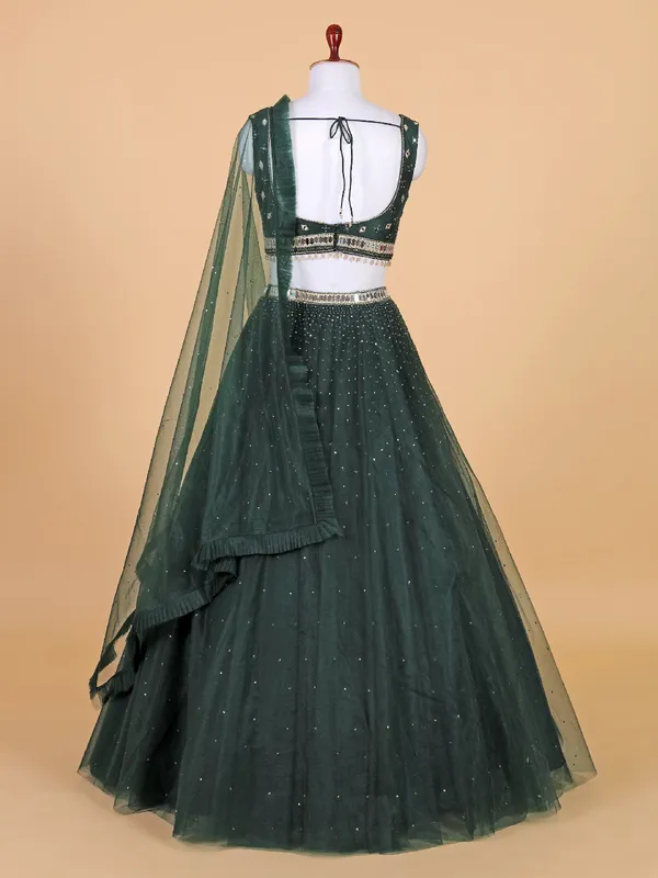 Fascinating dark green net lehenga choli
