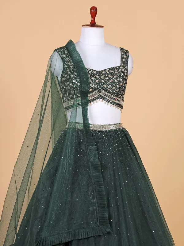 Fascinating dark green net lehenga choli
