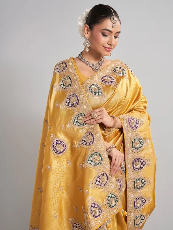 Mustard yellow tissue silk saree with rich embellished work