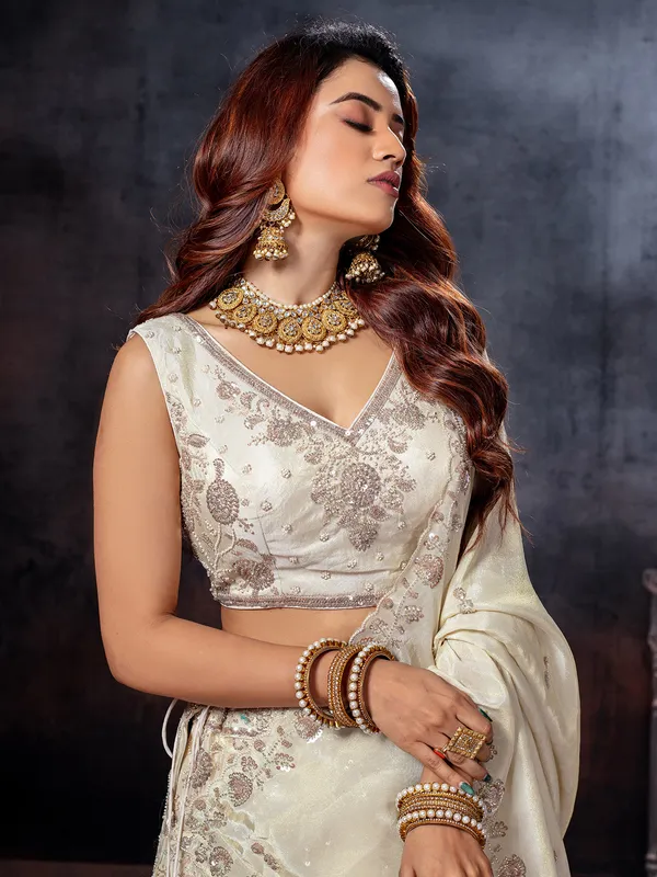 Off white sleeveless tissue silk lehenga choli