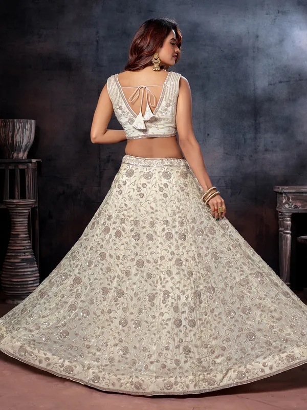 Off white sleeveless tissue silk lehenga choli
