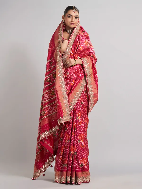 Rani pink patola silk saree with heavy bridal embellishments