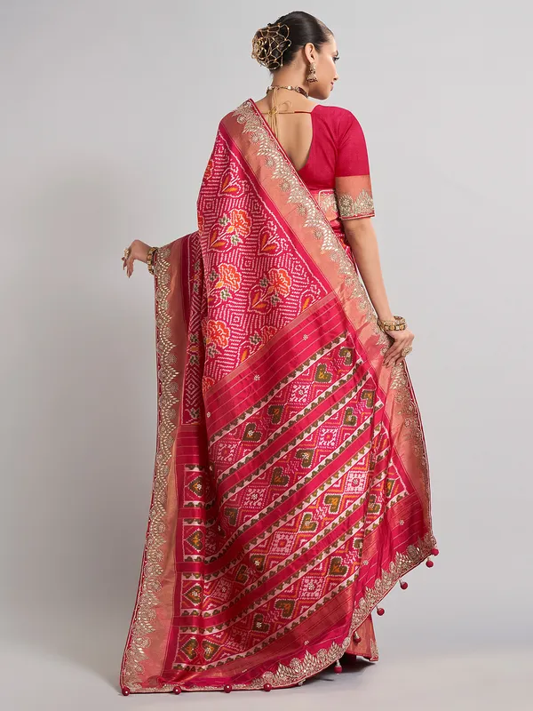 Rani pink patola silk saree with heavy bridal embellishments
