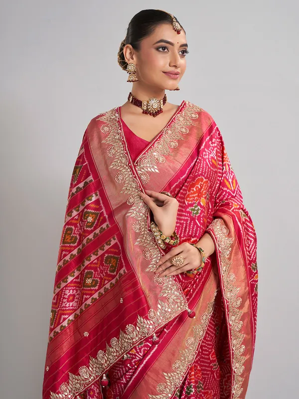 Rani pink patola silk saree with heavy bridal embellishments