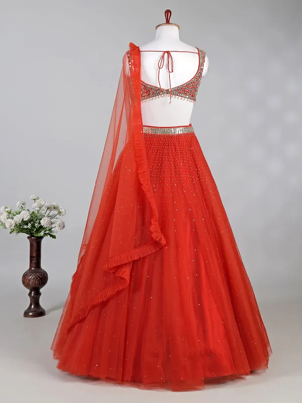 Rust red net lehenga choli with sparkling sequins