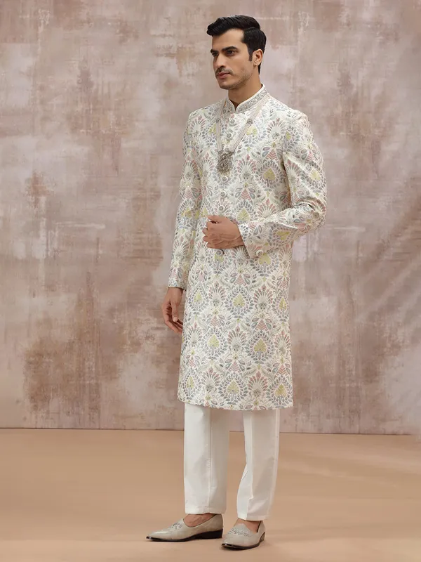 white silk sherwani with vibrant embroidery detailing