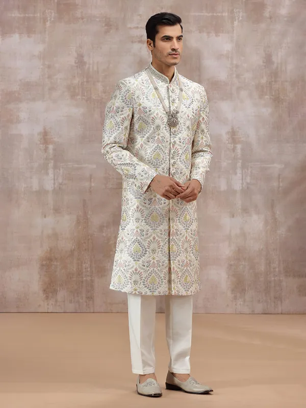 white silk sherwani with vibrant embroidery detailing