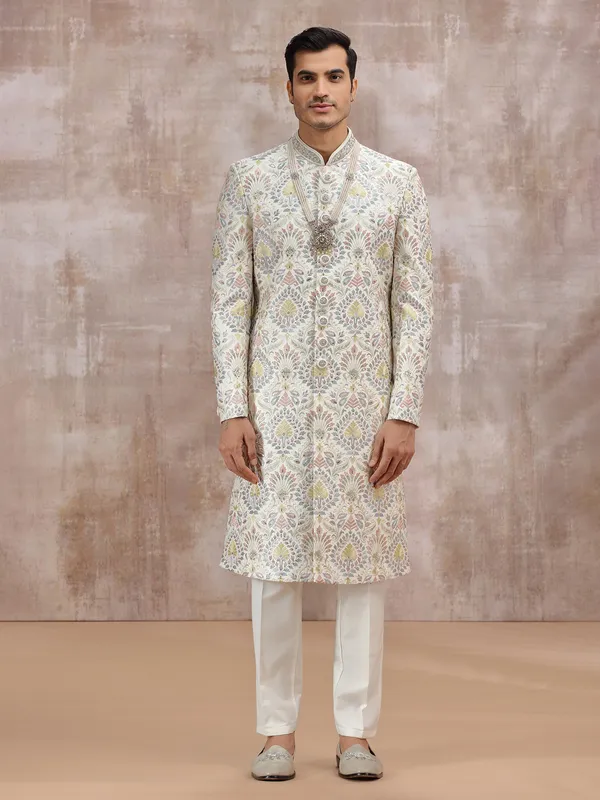 white silk sherwani with vibrant embroidery detailing