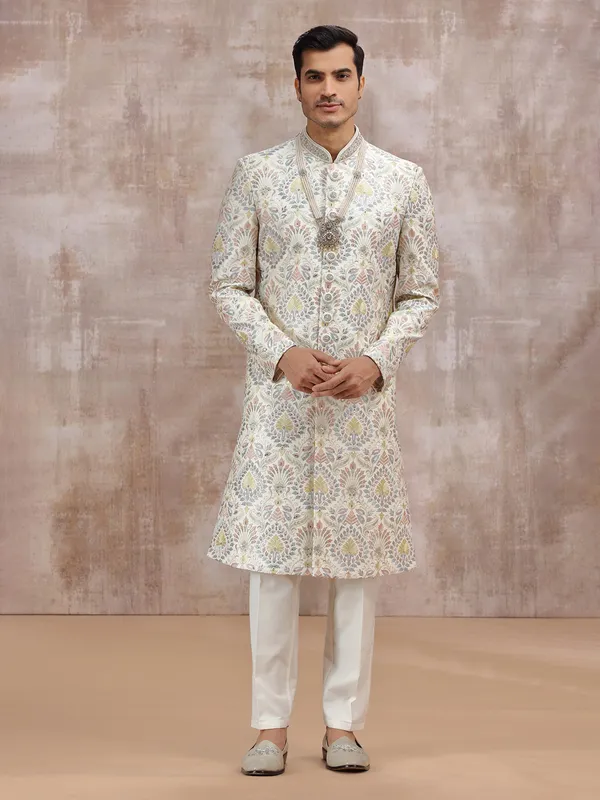 white silk sherwani with vibrant embroidery detailing