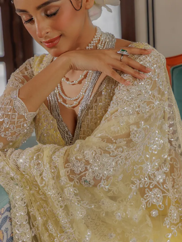 Yellow net saree for rich sequins work