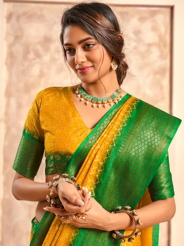 Yellow printed dola silk saree with green border