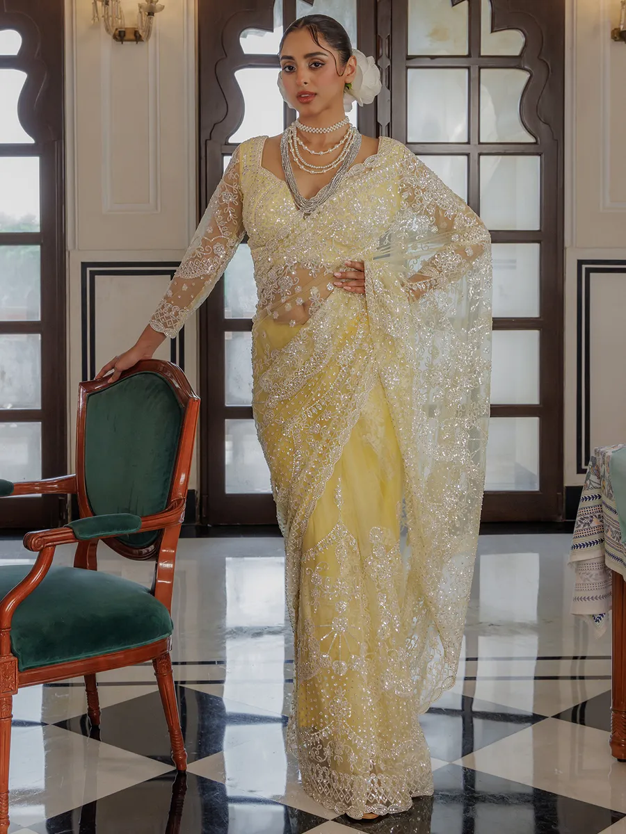Yellow net saree for rich sequins work