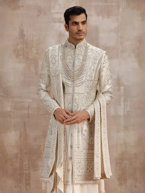 Cream silk peshwai sherwani paired with dupatta