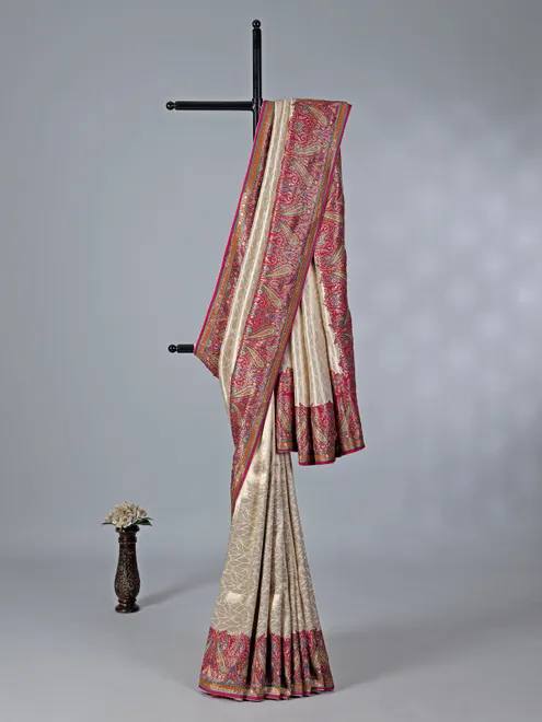 Cream tissue silk saree with colorful motifs embellishments