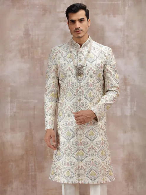 white silk sherwani with vibrant embroidery detailing